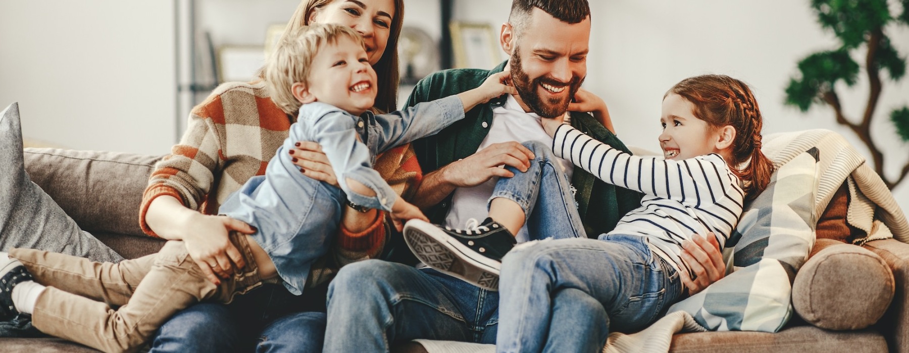 a family laughing on a sofa