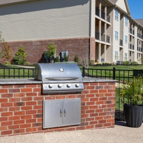 a brick wall with a fence and a building in the background